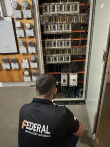 Técnico da Federal Instalações trabalhando em quadro elétrico